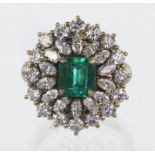 18ct yellow gold dress cluster ring set with a central rectangular step cut emerald of fine colour