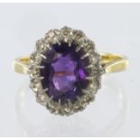 9ct yellow gold cluster ring set with central amethyst measuring approx. 10mm x 8mm, surrounded by