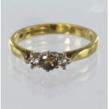 18ct yellow gold trilogy ring set with centre "champagne" coloured diamond and a white diamond