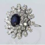 18ct white gold dress cluster ring comprising a central oval sapphire measuring approx. 9mm x 7mm