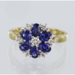 18ct yellow gold cluster ring featuring six oval blue sapphires surrounding a round brilliant cut