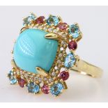 14ct yellow gold dress ring set with a central cushion cut blue cabochon surrounded by a row of