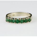 18ct white gold half eternity ring set with seven 3mm round emeralds in claw settings, stamped