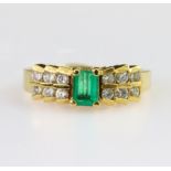 18ct yellow gold ring set with a central rectangular step cut emerald measuring approx. 5 x 4mm,