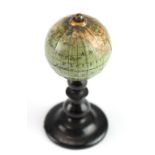 Miniature globe, circa 19th Century, on a turned ebonised stand, height 55mm, diameter 25mm approx.