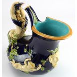 Minton majolica wine jug with a mermaid forming the handle of the jug, covered in vines. A cherub