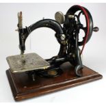 Sewing Machine. A cast iron sewing machine by Wilcox & Gibbs, height 26cm, length 32.5cm approx. (