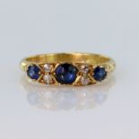 18ct yellow gold carved head ring set with three graduated sapphires divided by four round old cut