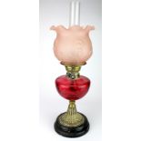 Oil Lamp. A brass based oil lamp, circa late Victorian, with inner glass tube & frosted pink glass