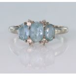 18ct white gold ring set with three oval blue topaz with four diamond highlights totalling approx.