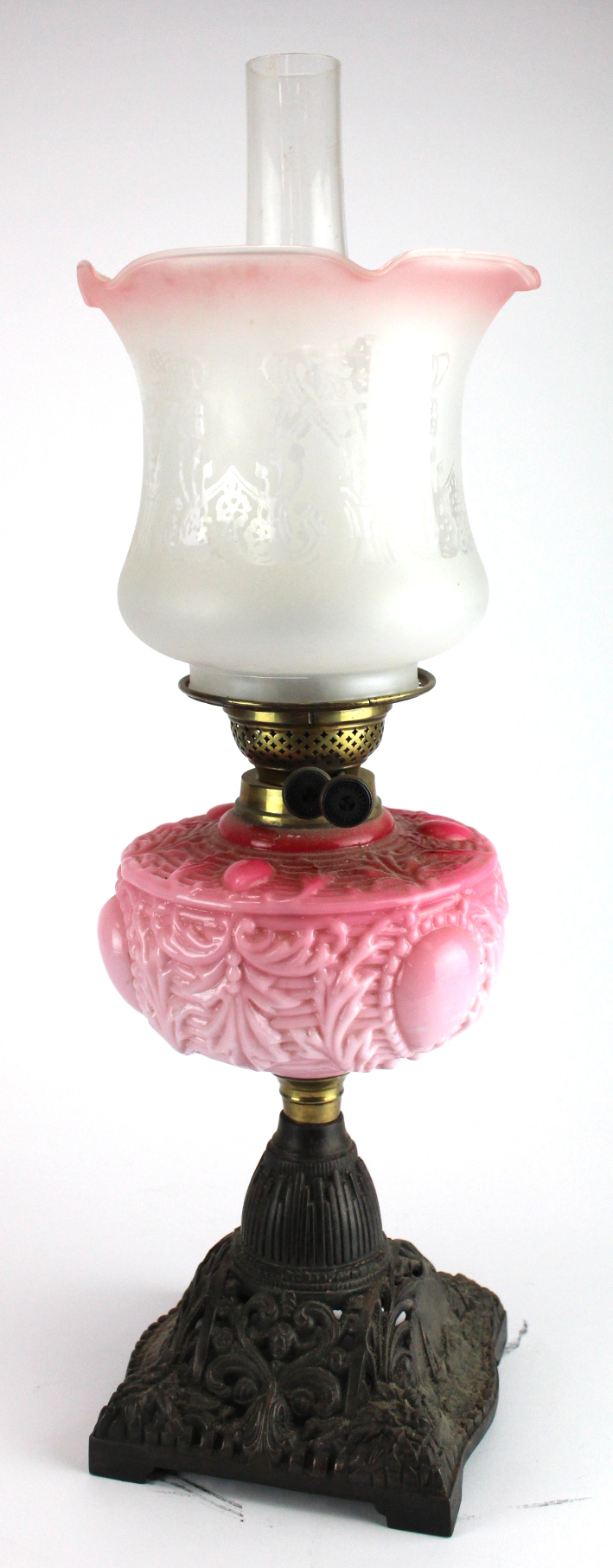 Oil Lamp. An iron based oil lamp, circa late Victorian, with inner glass tube & frosted / pink glass