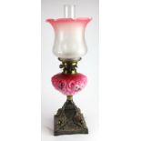 Oil Lamp. An iron based oil lamp, circa late Victorian, with inner glass tube & frosted / pink glass