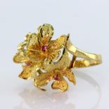 High carat yellow gold dress ring depicting four flowers with ruby centre, finger size N, weight 5.