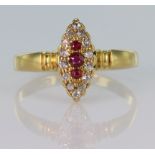 18ct yellow gold marquise shaped ring set with three graduated rubies surrounded by fourteen round