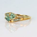 9ct yellow gold crossover style ring set with two trilliant cut alexandrite, with six further