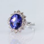 18ct white gold ring featuring a central oval tanzanite weighing 3.92ct, surrounded by fourteen