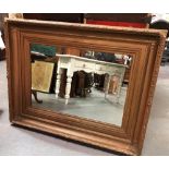 A large gilt gesso rectangular picture frame inset with a mirror, aperture size 59cm x 87cm