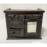 A 20th Century oak small wall hanging cupboard with a pair of antique carved doors, one with a