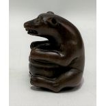 Japanese carved wood netsuke carved in the form of a seated bear holding a pot, height 4cm