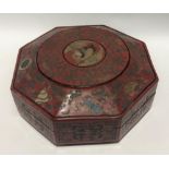 A Chinese red lacquer octagonal lidded box, the lid decorated with a bird amongst chrysanthemum