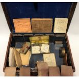 A vintage tan leather case containing fishing tackle including two boxed Hardy Bros flies.
