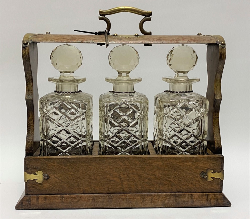An oak brass bound three-section tantalus enclosing three square section spirit bottles with - Image 2 of 2