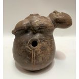 A possibly pre-Columbian, Chimu terracotta pot applied to the top with a figure on an ovoid base,