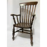 A beech and elm seat lath back Windsor elbow chair with turned legs united by a stretcher, height