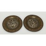 A pair of Indian brass, copper and white metal applied embossed circular dishes, the wells both