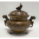 A Chinese lidded bronze censer, the key pierced lid with Buddhistic lion finial and Buddhistic