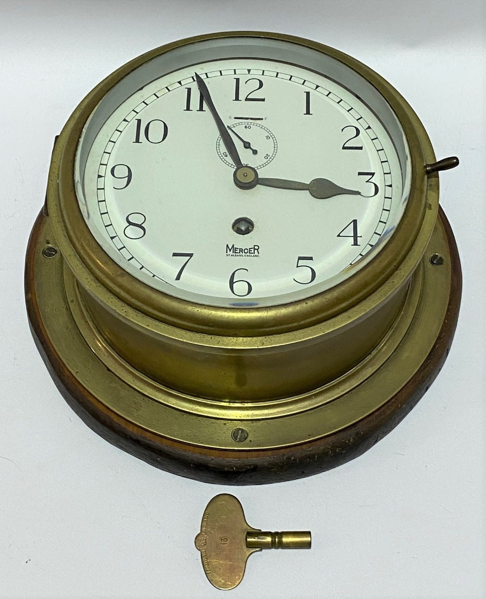 A brass ship's bulkhead wall clock, the 7 inch enamel dial with black Arabic numerals signed 'MERSER - Image 2 of 2