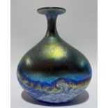 A Norman Stuart Clarke iridescent glass bottle vase of ovoid flattened form with wave design, signed