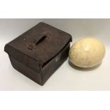 An antique ostrich egg, length 15cm, within tan leather case