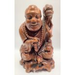 Chinese root carved figure of a sage seated holding a whip and prayer beads, bone inset eyes and