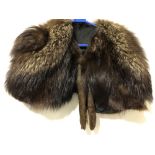 A brown fox fur cape with black silk lining.