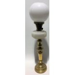 A brass oil lamp with white opaque glass reservoir and ovoid white glass shade, height 58cm