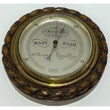 An aneroid barometer within carved oak rope twist case, the 4.5 inch silvered dial signed 'Short &
