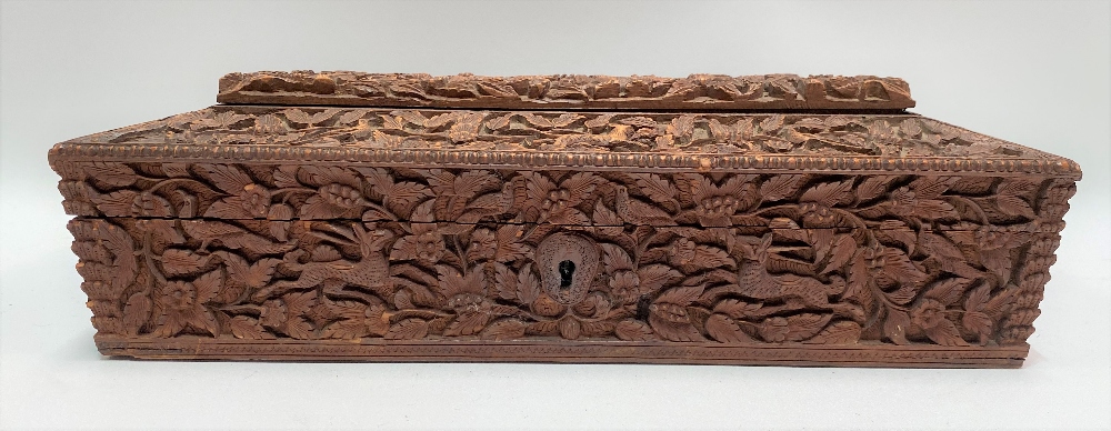 An Indian carved teak rectangular hinge lidded stationery box, with caddy top, the whole profusely