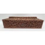 An Indian carved teak rectangular hinge lidded stationery box, with caddy top, the whole profusely