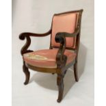 A 19th Century French mahogany elbow chair, circa 1840, with upholstered back and feet with outswept