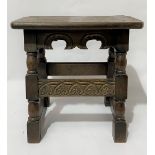 A 16th Century style oak stool with shaped frieze and carved stretcher, width 46cm