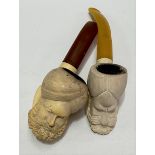 Two Meerschaum pipes, with amber mouth pieces, the bowls carved as turbaned gentlemen