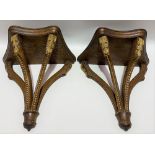 A pair of mahogany wall brackets with four beaded and leaf carved supports with gilded highlights,