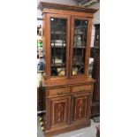 An Edwardian walnut and marquetry Sheraton Revival bookcase, the moulded cornice over a pair of