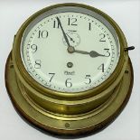 A brass ship's bulkhead wall clock, the 7 inch enamel dial with black Arabic numerals signed 'MERSER
