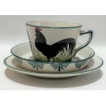 A Wemyss ware black cockerel decorated trio impressed and printed marks and retailed for T.