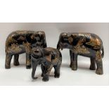A pair of Japanese black lacquer carved wood gilt painted opposing elephants, decorated with figures