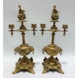 A pair of gilded twin branch candlesticks with seated woman finial, height 38cm