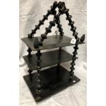 19th Century folk art ebonised three-tier wall hanging shelves with cotton reel supports, height