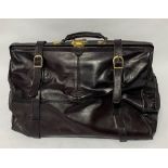 A brown leather holdall with brass fittings by Topcu, black leather interior with zipped pocke,